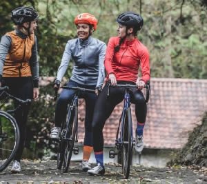 three people riding bike near trees during daytime