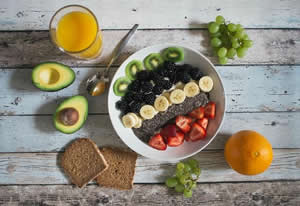 Bowl of colorful fruit with whole grain toast