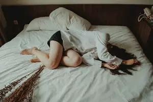 Woman laying in bed in pain