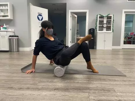 Therapist Nancy Hoi Wong OTR/L rolling piriformis on foam roller