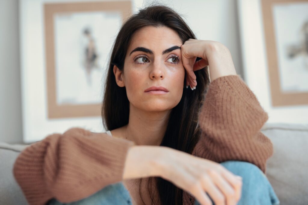 Woman in thoughtful distress representing living with undiagnosed pelvic floor tension
